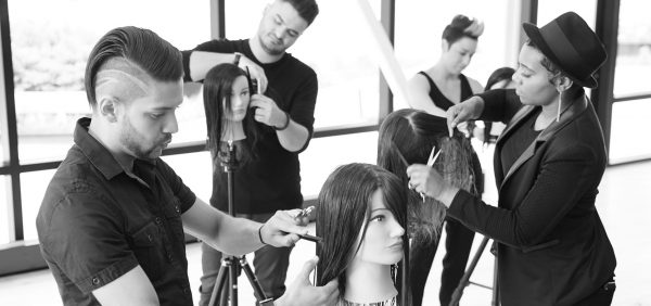 Hairdressing students styling mannequins